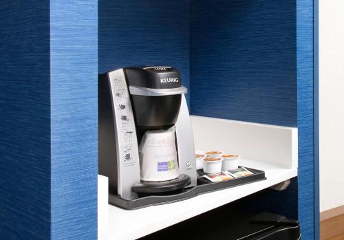 a coffee maker on a shelf in a kitchen at Holiday Inn Express Boston North-Woburn by IHG in Woburn