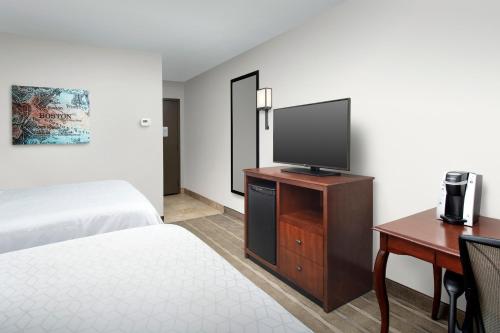 a hotel room with a bed and a flat screen tv at Holiday Inn Express Boston North-Woburn by IHG in Woburn
