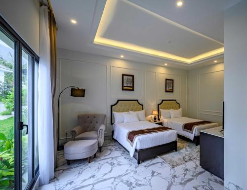 a hotel room with two beds and a couch at Seaside Boutique Resort Quy Nhon in Quy Nhon