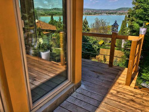 an open door to a balcony with a view of a lake at Villa Borostyán in Tihany