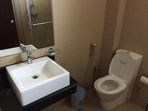 a bathroom with a white sink and a toilet at Oceanfront Condominiums - Nilaveli in Nilaveli