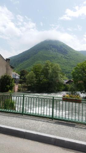a green fence with a mountain in the background at PAS à PAS CHAMBRE D'HOTES in Sarrancolin