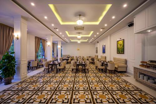 a restaurant with tables and chairs in a room at Seaside Boutique Resort Quy Nhon in Quy Nhon