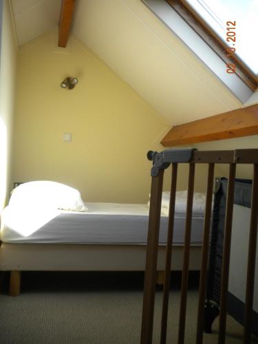 a bed in a room next to a staircase at Koetsementen appartementen met strandcabine in Domburg