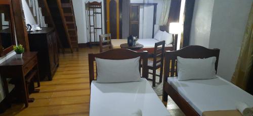 a living room with two chairs and a table at Escolta's Homey Lodge in Vigan