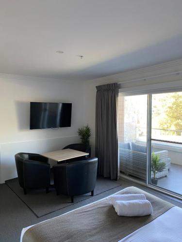 a living room with a table and chairs and a window at Huskisson Beach Motel in Huskisson