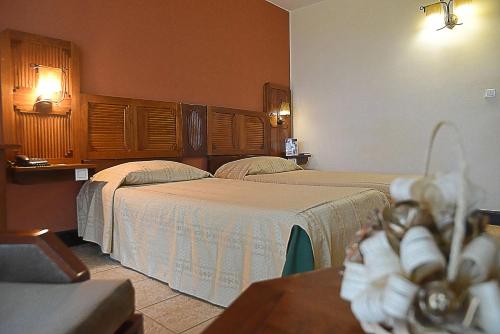 a hotel room with two beds and a table at Le Grand Hôtel Diego in Diego Suarez