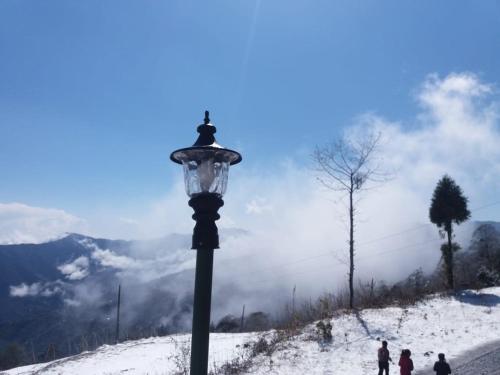 a street light next to a snow covered mountain at Vamoose Royal Barsey in Sombāri