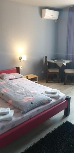 クルジュ・ナポカにあるGuest House Andreiのテーブルと椅子が備わる客室のベッド1台分です。