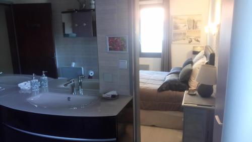 a bathroom with a sink and a bed in a room at VILLA Zaphira in Gujan-Mestras