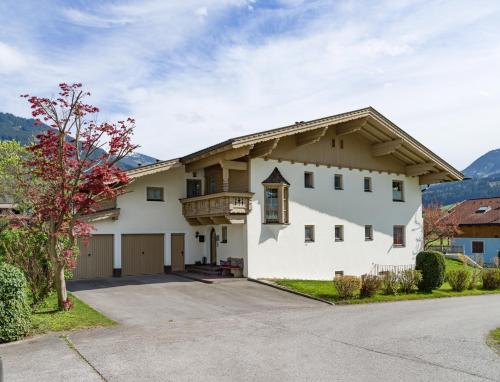 a large white house with a driveway at Ferienwohnung Huber in Stumm