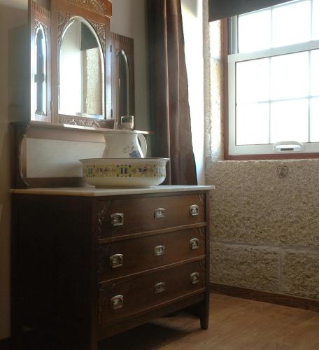 a bathroom with a dresser with a sink and a mirror at Casa Dos Lagares De Vara E Pedra in Vila Flor