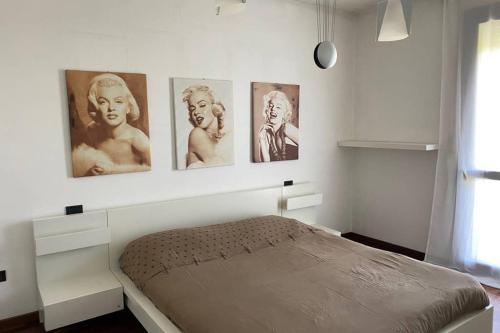 a bedroom with four pictures on the wall at Appartamento Girasole tra Padova e Venezia in Fiesso dʼArtico