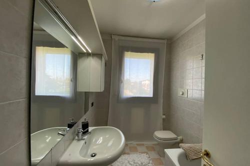 y baño con lavabo, aseo y espejo. en Appartamento Girasole tra Padova e Venezia, en Fiesso dʼArtico