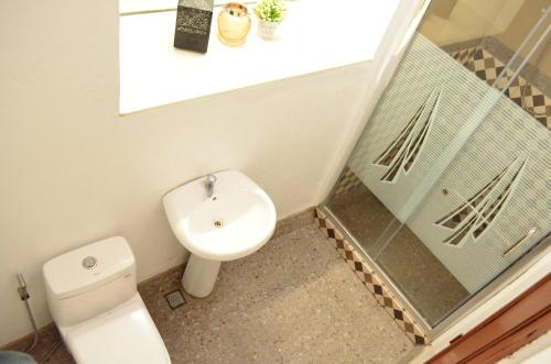 a small bathroom with a toilet and a sink at Escolta's Homey Lodge in Vigan