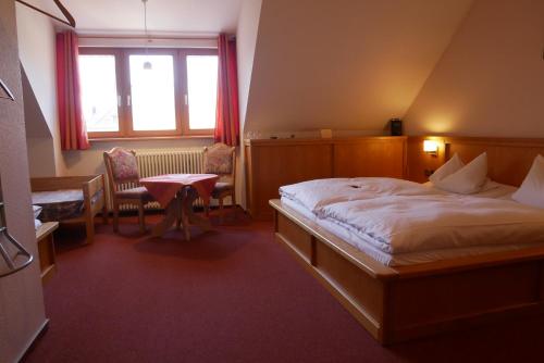 a hotel room with a bed and a table at Hotel Gasthof Hereth in Wirsberg