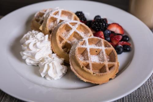 a plate with waffles and fruit on a table at Holiday Inn & Suites Philadelphia W - Drexel Hill by IHG in Drexel Hill