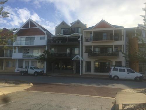 a large building with cars parked in front of it at Breakwater Short Stay in Mandurah