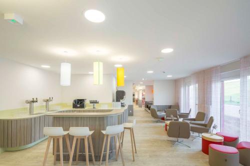 a lobby with a bar with stools and a cafeteria at AS Ferienzentrum in Butjadingen