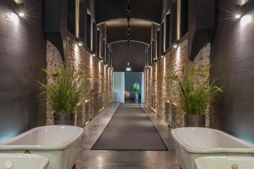 a bathroom with two tubs and plants on the walls at Hedon Spa & Hotel in Pärnu