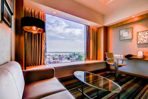a living room with a glass table and a large window at Radisson Blu Gorakhpur in Gorakhpur