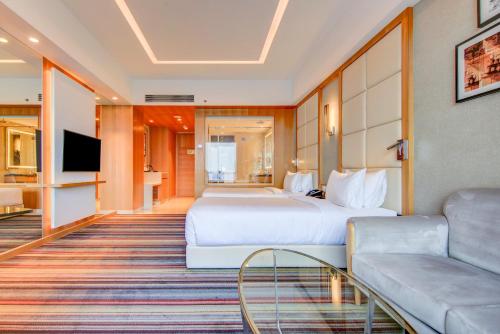 a hotel room with a bed and a couch at Radisson Blu Gorakhpur in Gorakhpur