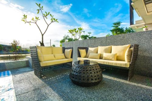 eine Terrasse mit 2 Sofas und einem Tisch in der Unterkunft MIKE B&B in Wujie