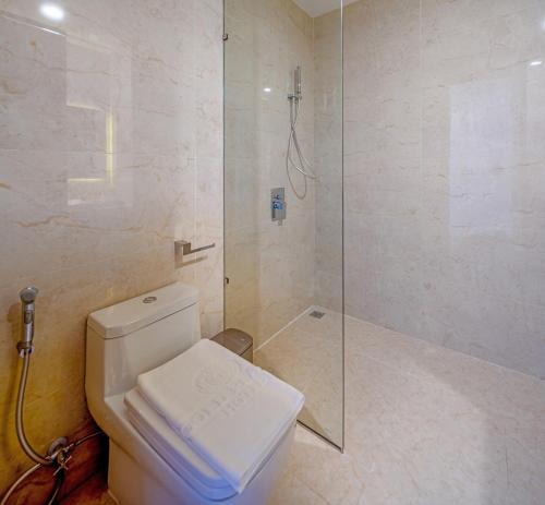 a bathroom with a toilet and a glass shower at Gold Plaza Hotel Da Nang in Da Nang