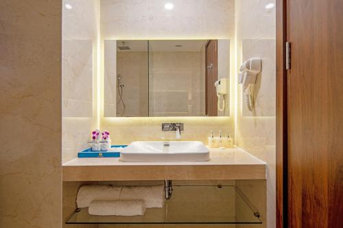 a bathroom with a sink and a mirror at Gold Plaza Hotel Da Nang in Da Nang