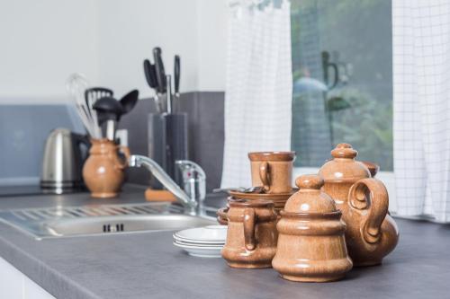 a kitchen counter top with wooden utensils and a sink at NordseeHeide-Lodges Cuxhaven in Cuxhaven