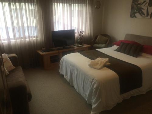 a hotel room with two beds and a flat screen tv at Breakwater Short Stay in Mandurah