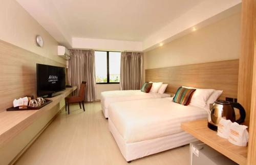 a hotel room with two beds and a television at Avana Laem Chabang Boutique Hotel in Ban Laem Chabang