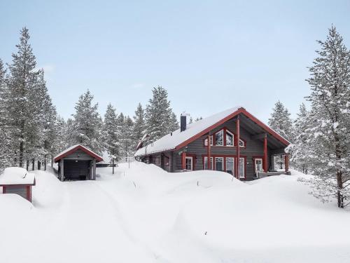 ルオストにあるHoliday Home Kerkänperä by Interhomeの雪の中の木々の丸太小屋
