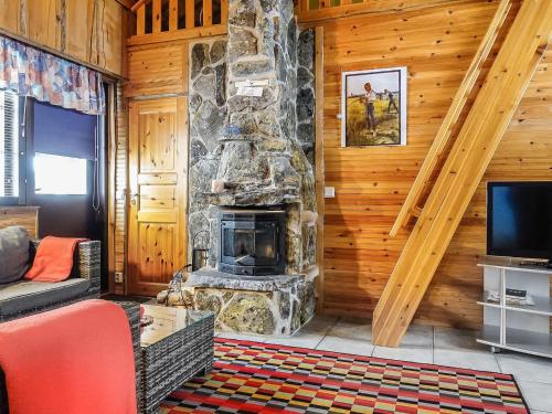 a living room with a stone fireplace in a cabin at Holiday Home Kantapää c 3 by Interhome in Luosto