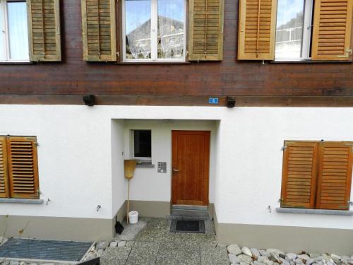 un edificio con una puerta y ventanas marrones en Apartment Hübeli - Chapman by Interhome en Zweisimmen
