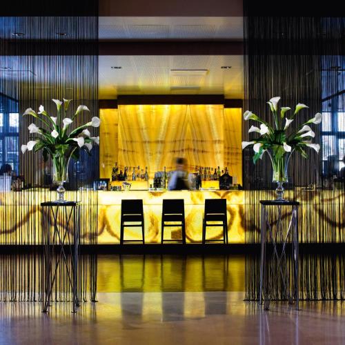 a lobby with two chairs and a table with flowers at Best Western Premier BHR Treviso Hotel in Quinto di Treviso