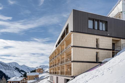 a building on top of a snow covered mountain at Alpenstern Panoramalodge in Damuls