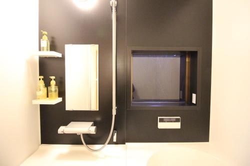 a bathroom with a shower with a toilet and a mirror at Mibuan in Kyoto