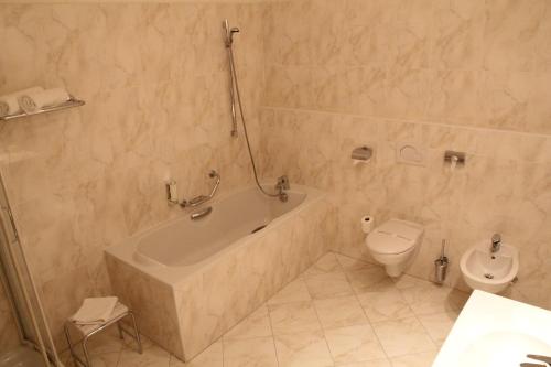 a bathroom with a bath tub and a toilet at Parkhotel Richmond in Karlovy Vary