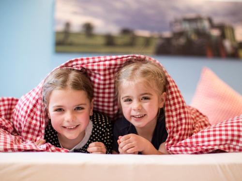twee kleine meisjes die onder een deken liggen bij Landhaus Schulte-Göbel in Schmallenberg