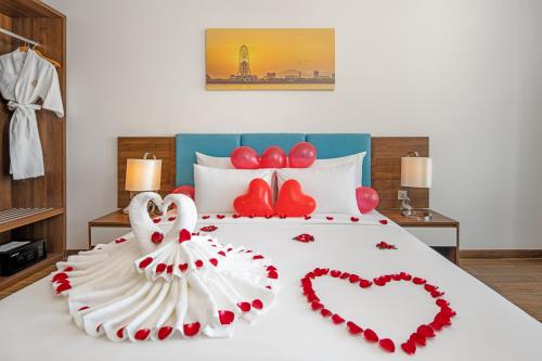 a bed with a heart made out of red pedals at Gold Plaza Hotel Da Nang in Da Nang