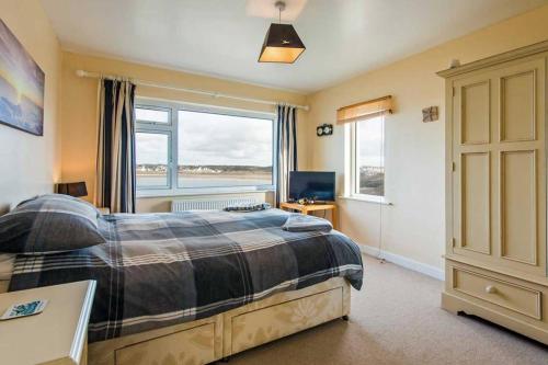 トレアルジルにあるAEL-Y-BRYN-5 BED- DRAMATIC SEA VIEWS - Sleeps 12のベッドと大きな窓のある寝室