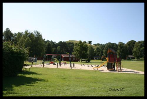 einen Park mit Spielplatz mit Rutsche und Spielgeräten in der Unterkunft Degeberga Stugby in Degeberga