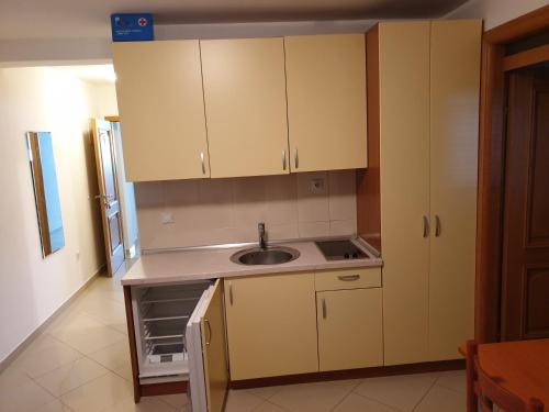 a kitchen with white cabinets and a sink at Apartments Knezović in Gradac