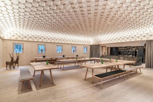 a room with tables and chairs and a ceiling at Hotel Bad Schörgau in Sarntal