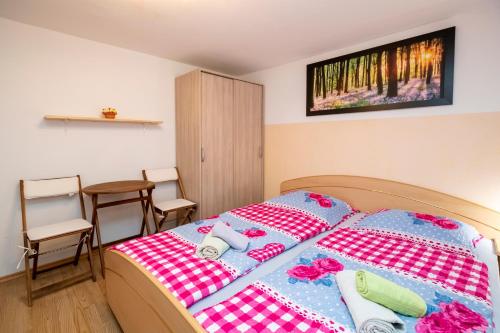 a bedroom with a bed and a table and chairs at Apartment Stare in Bohinj