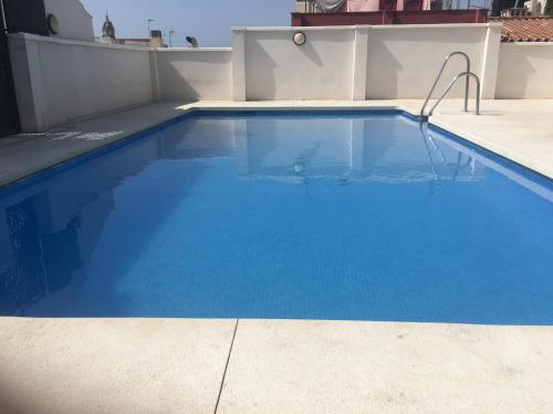 uma grande piscina azul no topo de um edifício em Pool and garage old town em Málaga
