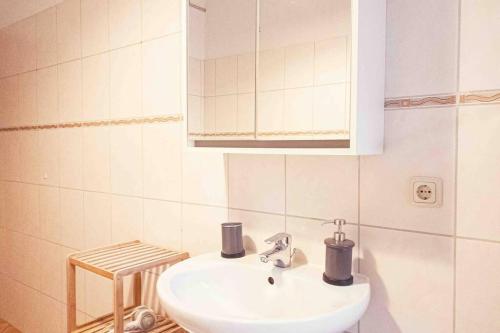 a white bathroom with a sink and a mirror at Altbauwohnung direkt an der Karli mit Balkon - Netflix inklusive in Leipzig