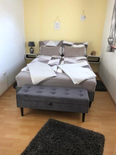 um quarto com uma cama grande e um repousa-pés azul em Ferienwohnung - Jakobs Hütte em Bad Berleburg