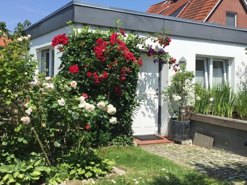 a white house with flowers on the door at Held Ursel in Neustadt in Holstein